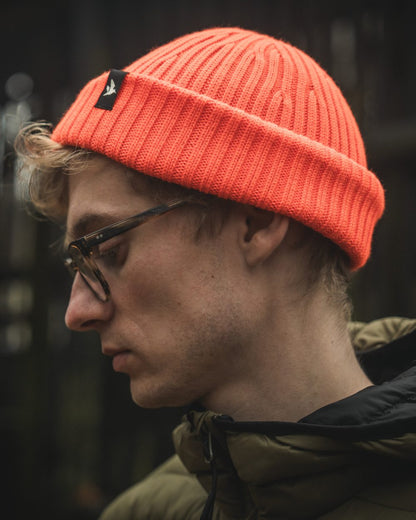 Orange Blaze Coloured Seeland Norite Beanie On A forest Background 