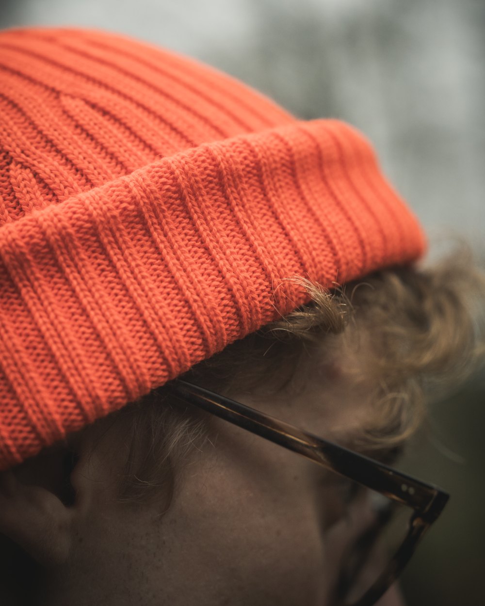 Orange Blaze Coloured Seeland Norite Beanie On A forest Background 