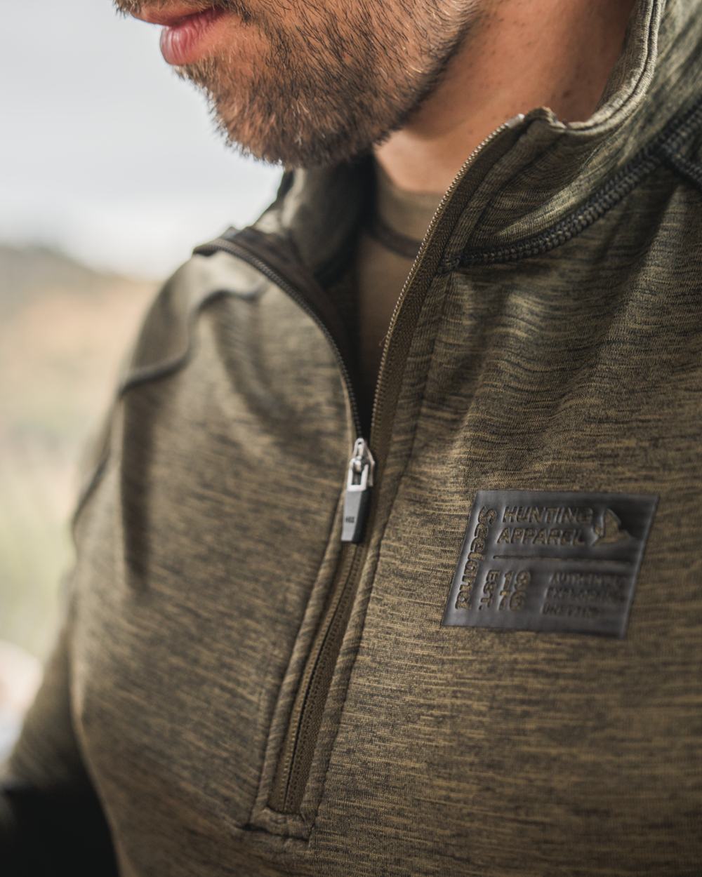 Pine Green Melange Coloured Seeland Peak Half Zip on outdoor background 