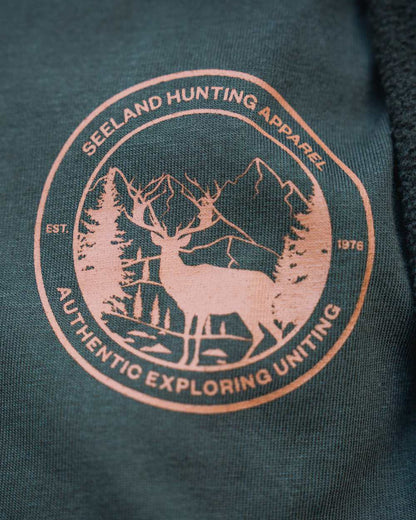 Pine Green Coloured Seeland Womens Hunting Heritage T-Shirt on forest background 