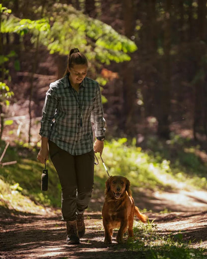 Pine Green coloured Seeland Womens Larch Stretch Trousers on forest background 