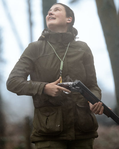Shaded Olive coloured Seeland Womens Woodcock Royale Eve Jacket on forest background 