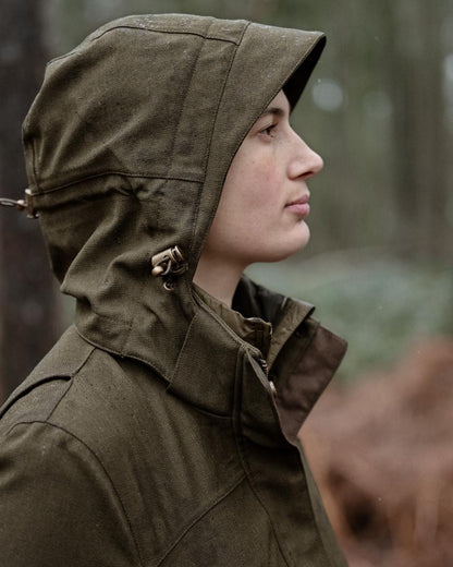 Shaded Olive coloured Seeland Womens Woodcock Royale Eve Jacket on forest background 