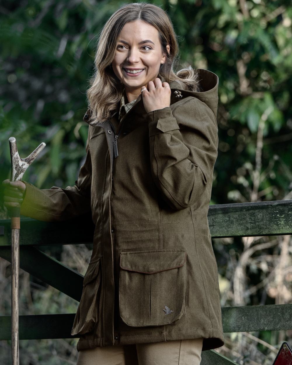 Shaded Olive coloured Seeland Womens Woodcock Royale Eve Jacket on forest background 