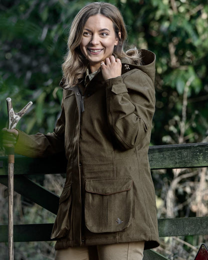 Shaded Olive coloured Seeland Womens Woodcock Royale Eve Jacket on forest background 
