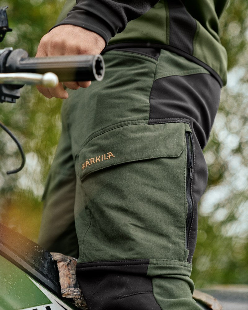 Person wearing Härkila outdoor trousers while riding an ATV outdoors