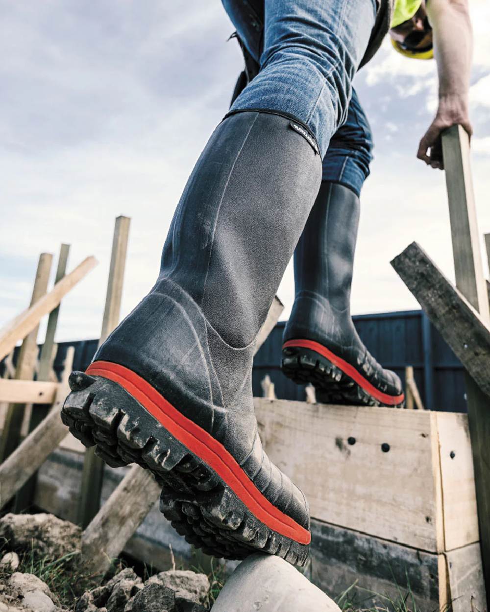 Black Red coloured Skellerup Quatro Super Safety S5 Insulated Black Boot on construction site background 