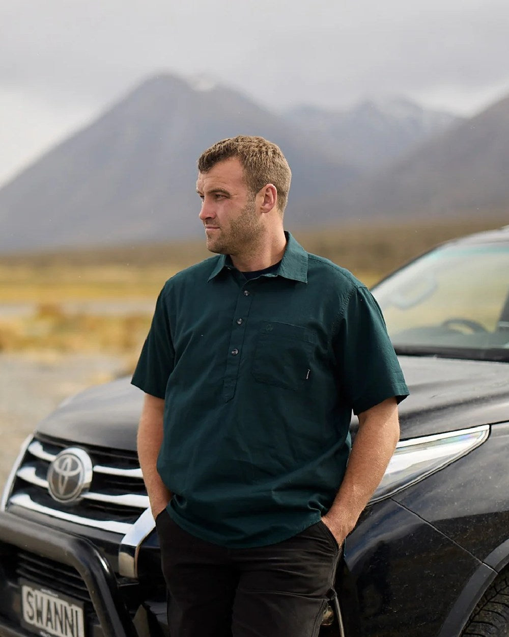 Forest Green Coloured Swanndri Mens Paihia Short Sleeve Shirt on mountain background 