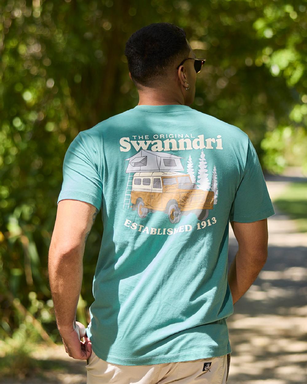 Jade Green Light Taupe Coloured Swanndri Mens Pop Top Printed T Shirt on street background 