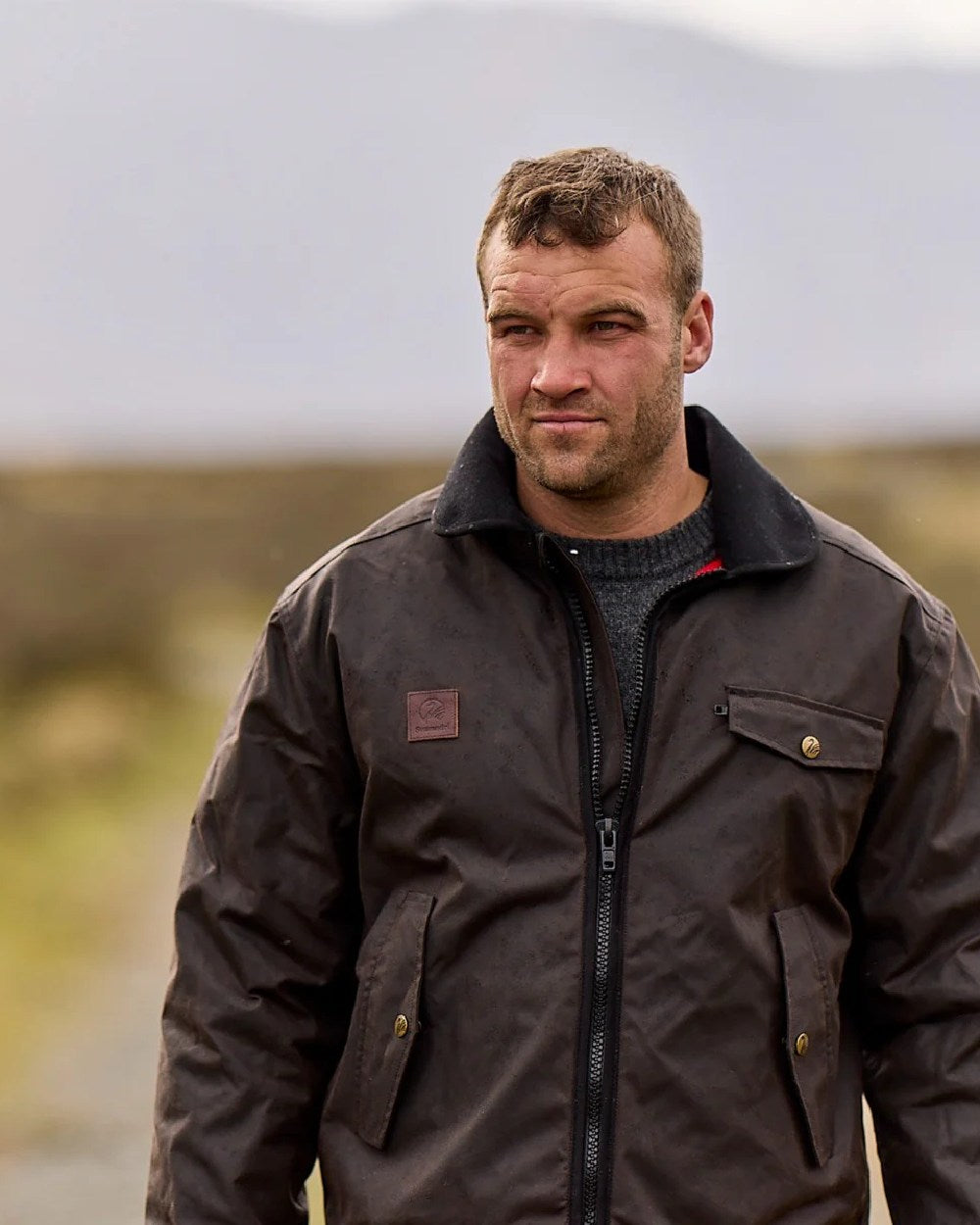 Brown Coloured Swanndri Mens Waimak Oilskin Jacket with Wool Lining on blurry background 