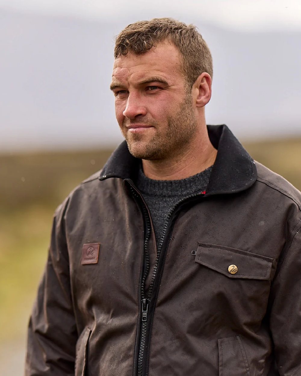 Brown Coloured Swanndri Mens Waimak Oilskin Jacket with Wool Lining on blurry background 