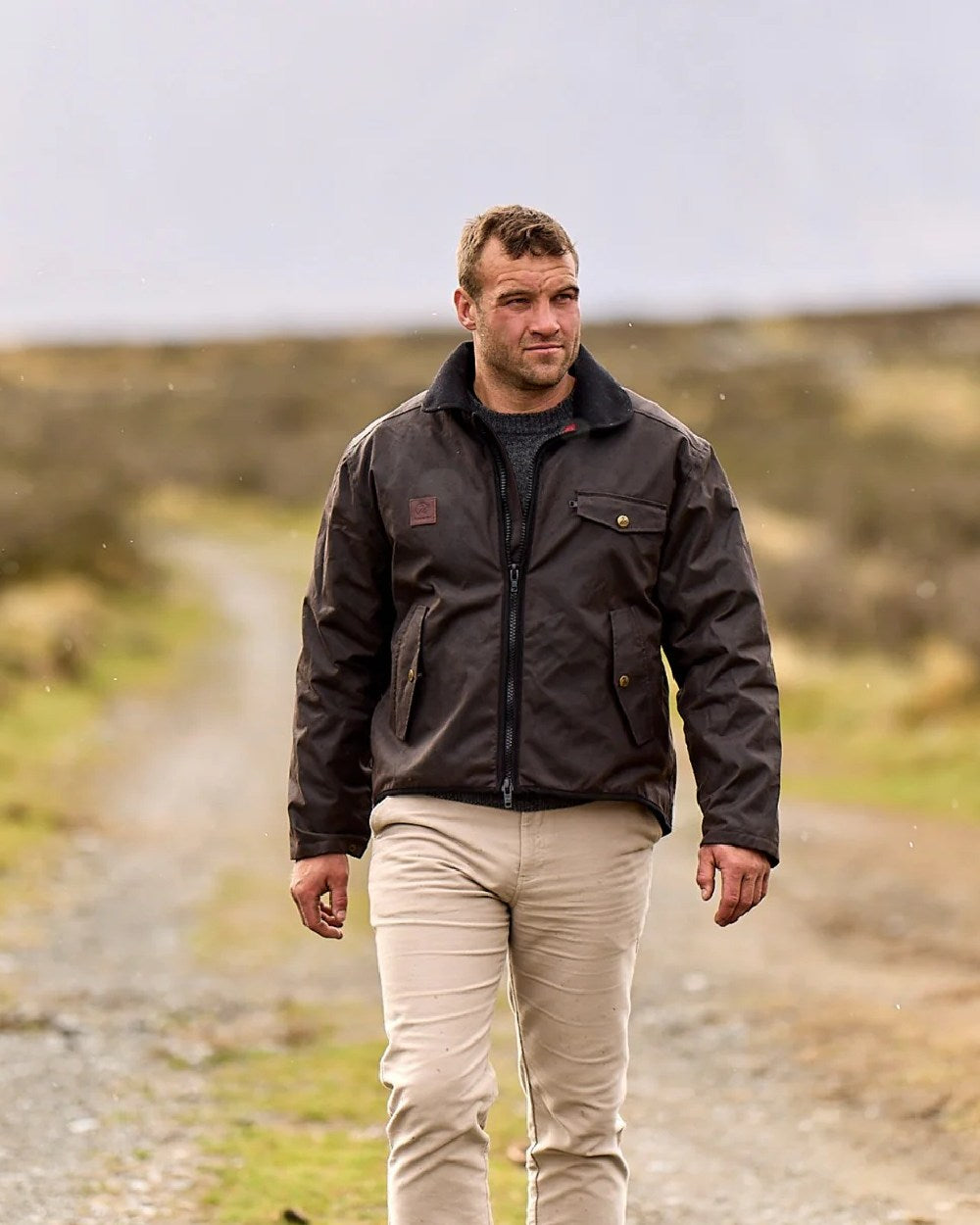 Brown Coloured Swanndri Mens Waimak Oilskin Jacket with Wool Lining on blurry background 