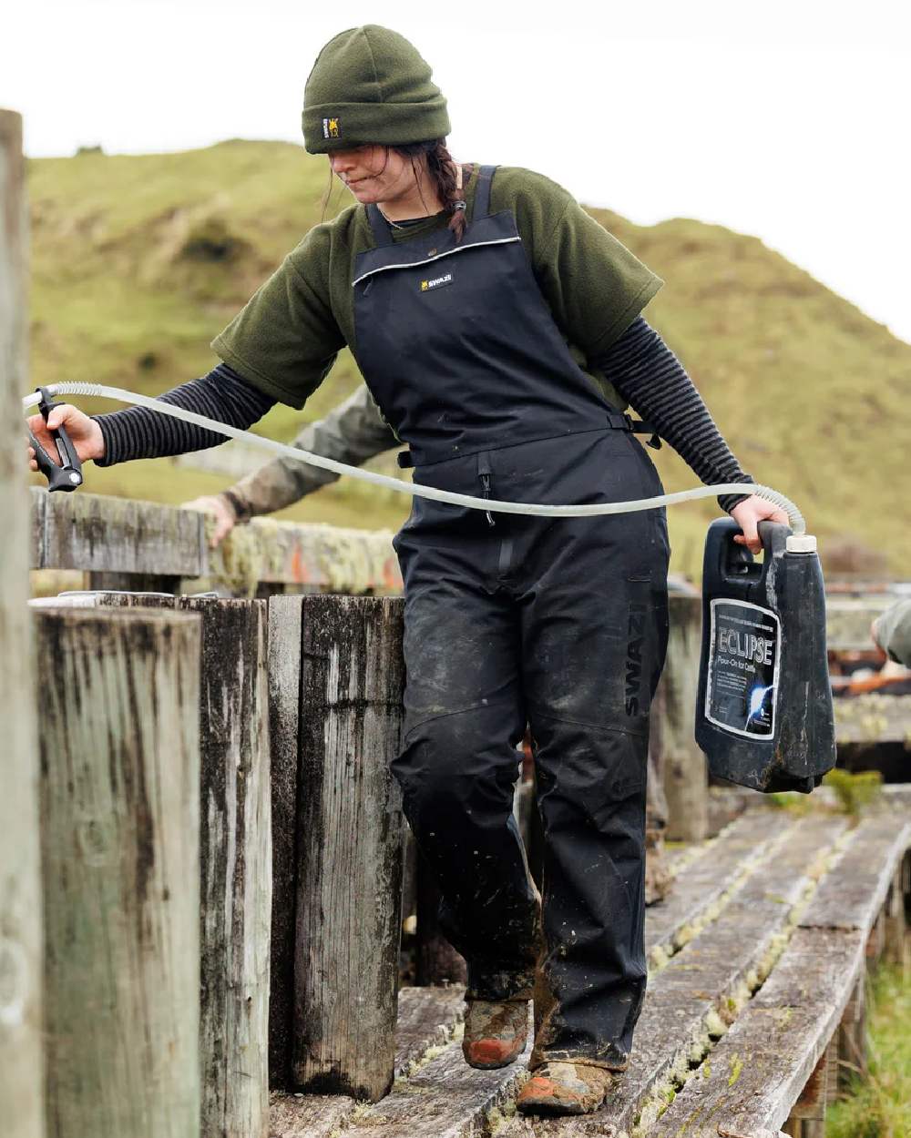 Black coloured Swazi Mens Torrent Bib Overpants on fences background 