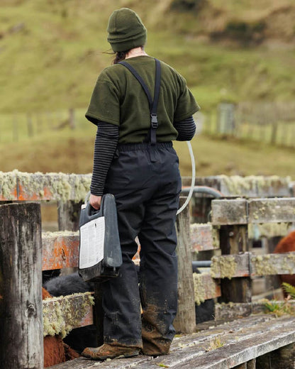 Black coloured Swazi Mens Torrent Bib Overpants on fences background 