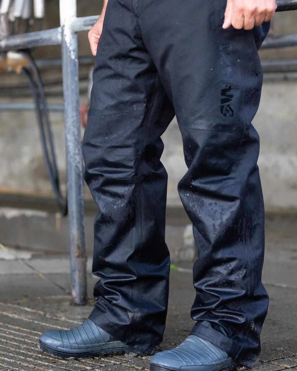 Black coloured Swazi Mens Torrent Bib Overpants on floor background 