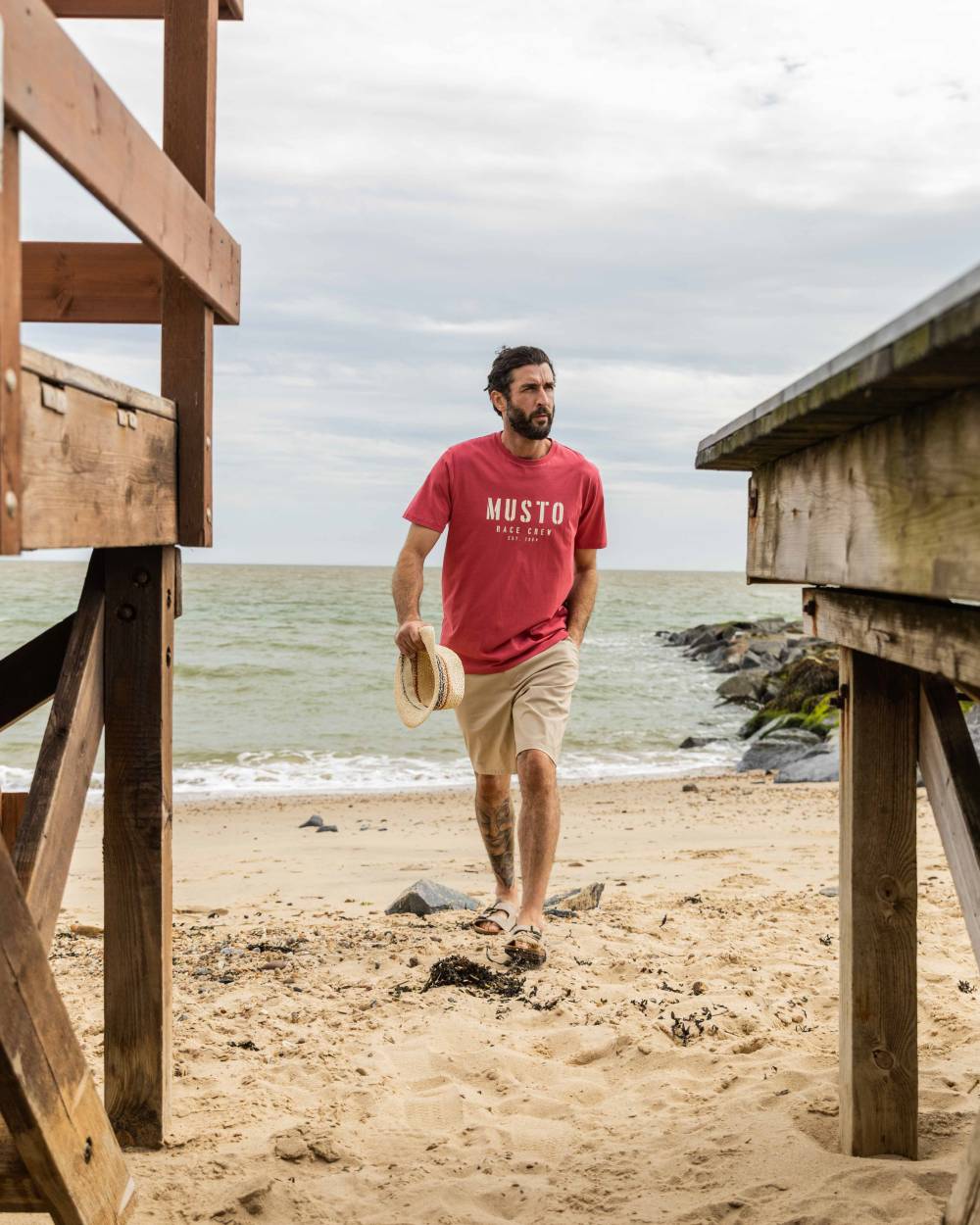 Sweet Raspberry Coloured Musto Mens Classic Short Sleeve T-Shirt On A Beach Background 