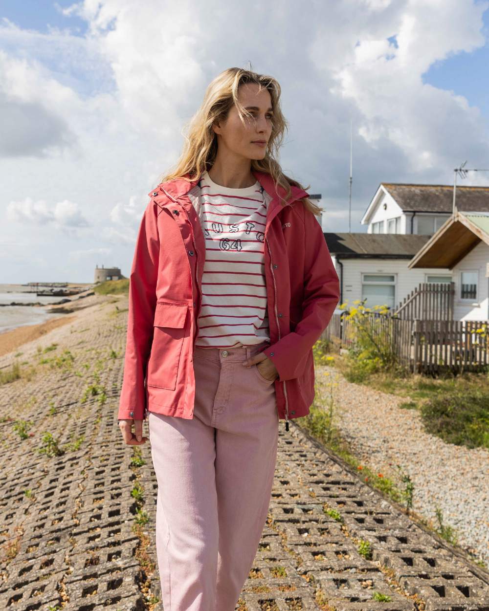 Sweet Raspberry Coloured Musto Womens Classic Shore Waterproof Jacket On A Coastal Background 