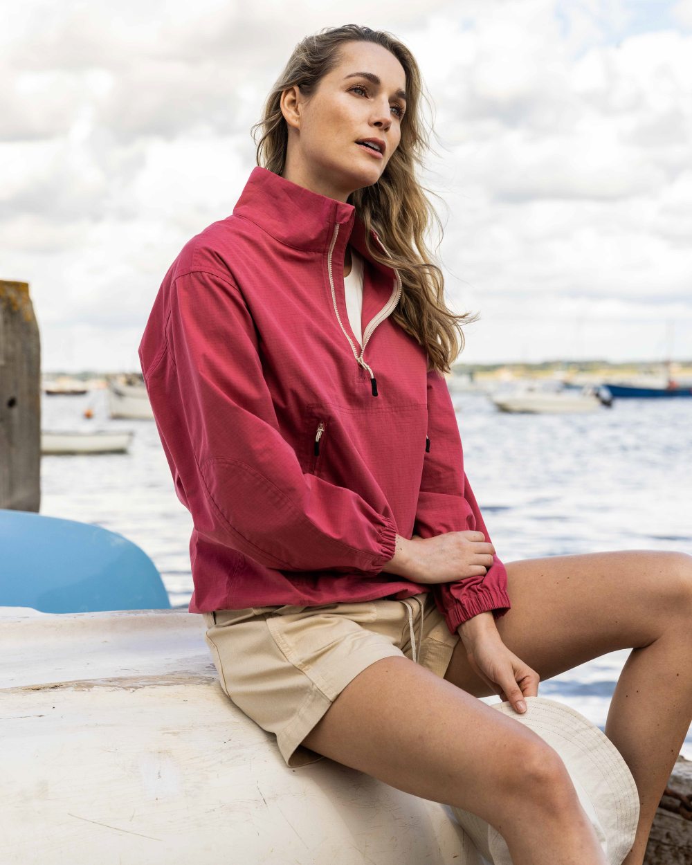 Sweet Raspberry Coloured Musto Womens Falmouth Anorak Jacket On A Beach Background 