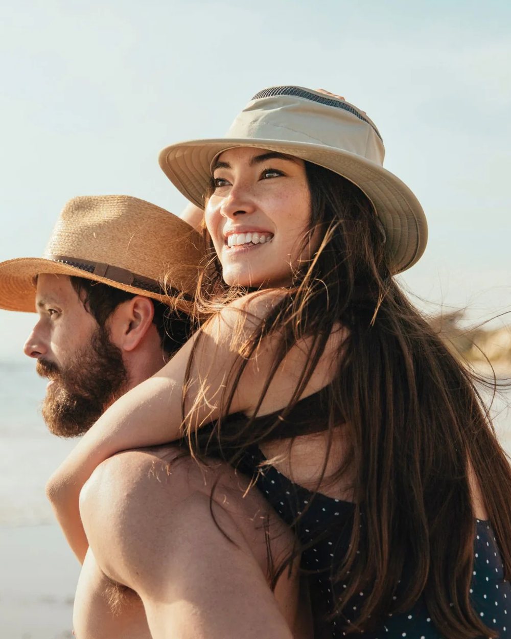 Rock Face Coloured Tilley Airflo Medium Brim Recycled Hat on beach background 