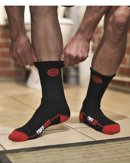 Man wearing a pair of TuffStuff Extreme Socks work socks in Black with red detail .
