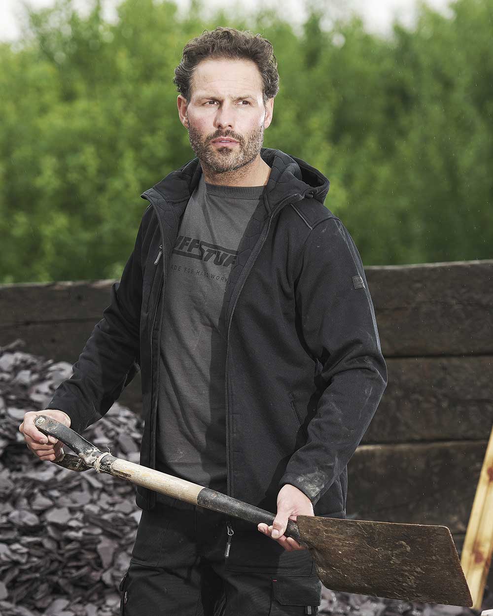 Man working with shovel wearing TuffStuff Hale Jacket in  black 
