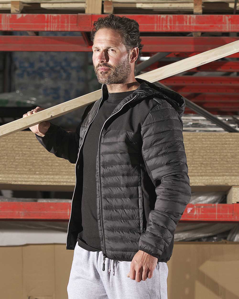 Man working with a plank wearing Black TuffStuff Hatton Softshell and Quilted Jacket