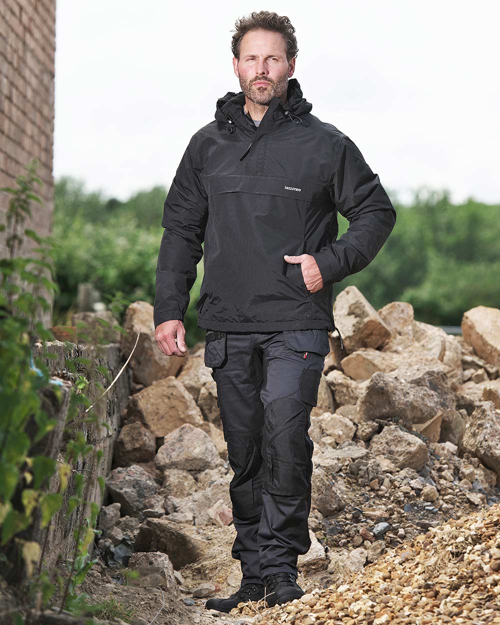Man on a pile of rubble wearing TuffStuff X Motion Work Trousers