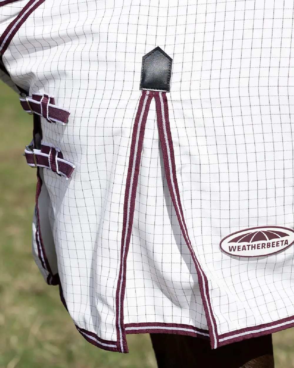 White maroon coloured WeatherBeeta Hybrid Seasons Combo Neck on blurry green background 