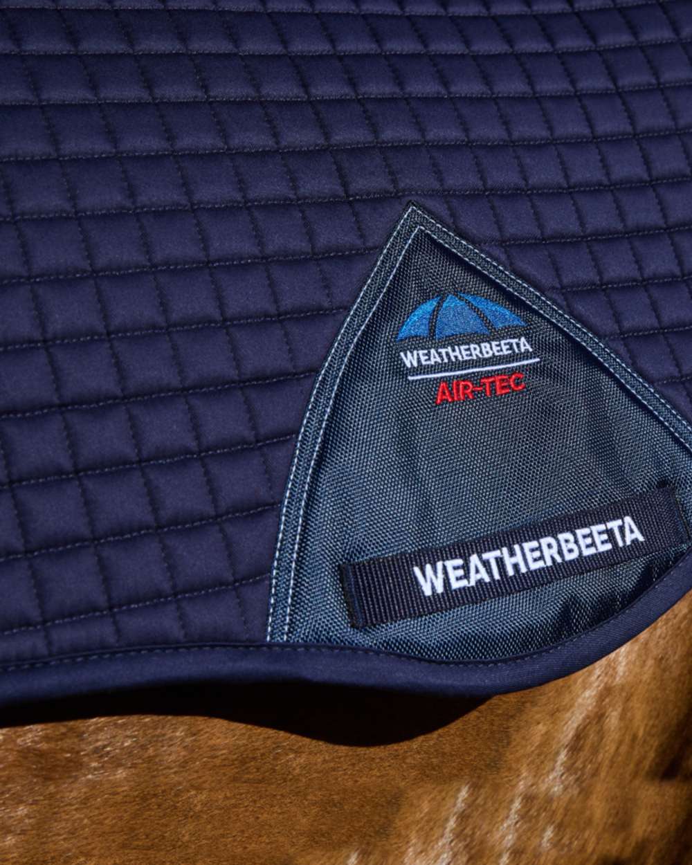 Navy Coloured WeatherBeeta Prime Air-Tec All Purpose Saddle Pad on horse background 