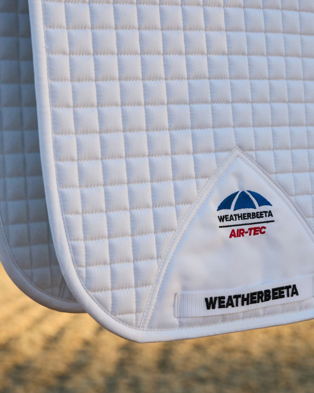 White Coloured WeatherBeeta Prime Air-Tec Dressage Saddle Pad on outdoor background 
