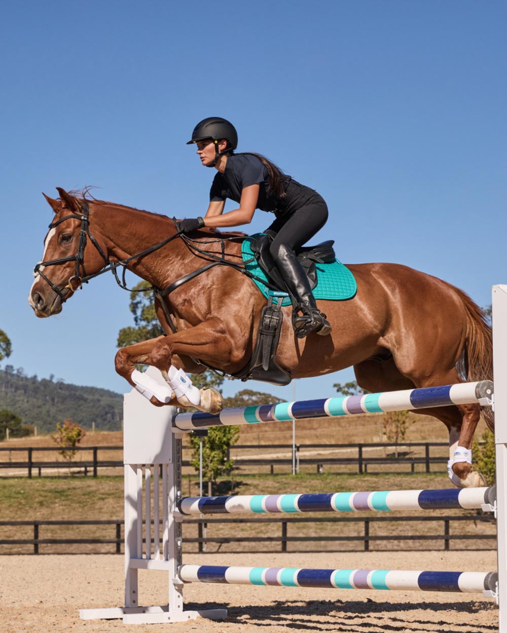 Dark Turquoise Coloured WeatherBeeta Prime Air-Tec Jump Shaped Saddle Pad on horse background 
