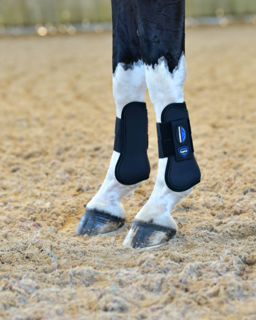 Black Coloured WeatherBeeta Tough-Tec Prime Open Front Boots on horse background 