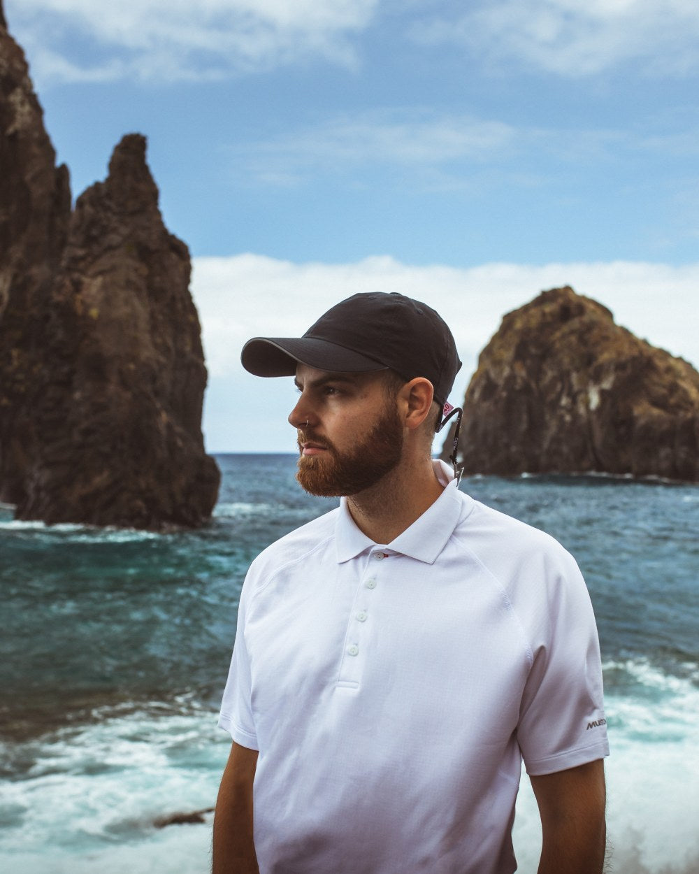 White Coloured Musto Mens Evolution Sunblock Short Sleeve Polo Shirt 2.0 On A Ocean Background 