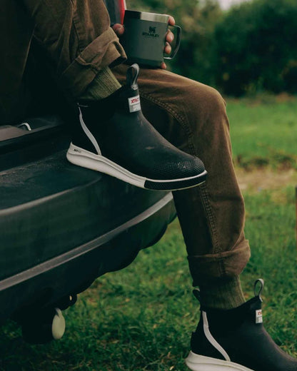 Black Coloured Xtratuf Mens 6&quot; Ankle Deck Sport Boots on outdoor background 