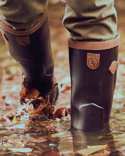 Dark Brown Coloured Aigle Parcours 2 Signature Wellingtons On A Forest Background