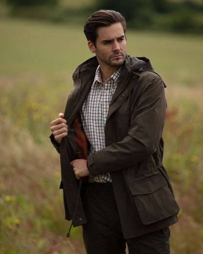 Olive Coloured Alan Paine Mens Lockwood Shooting Coat On A Forest Background