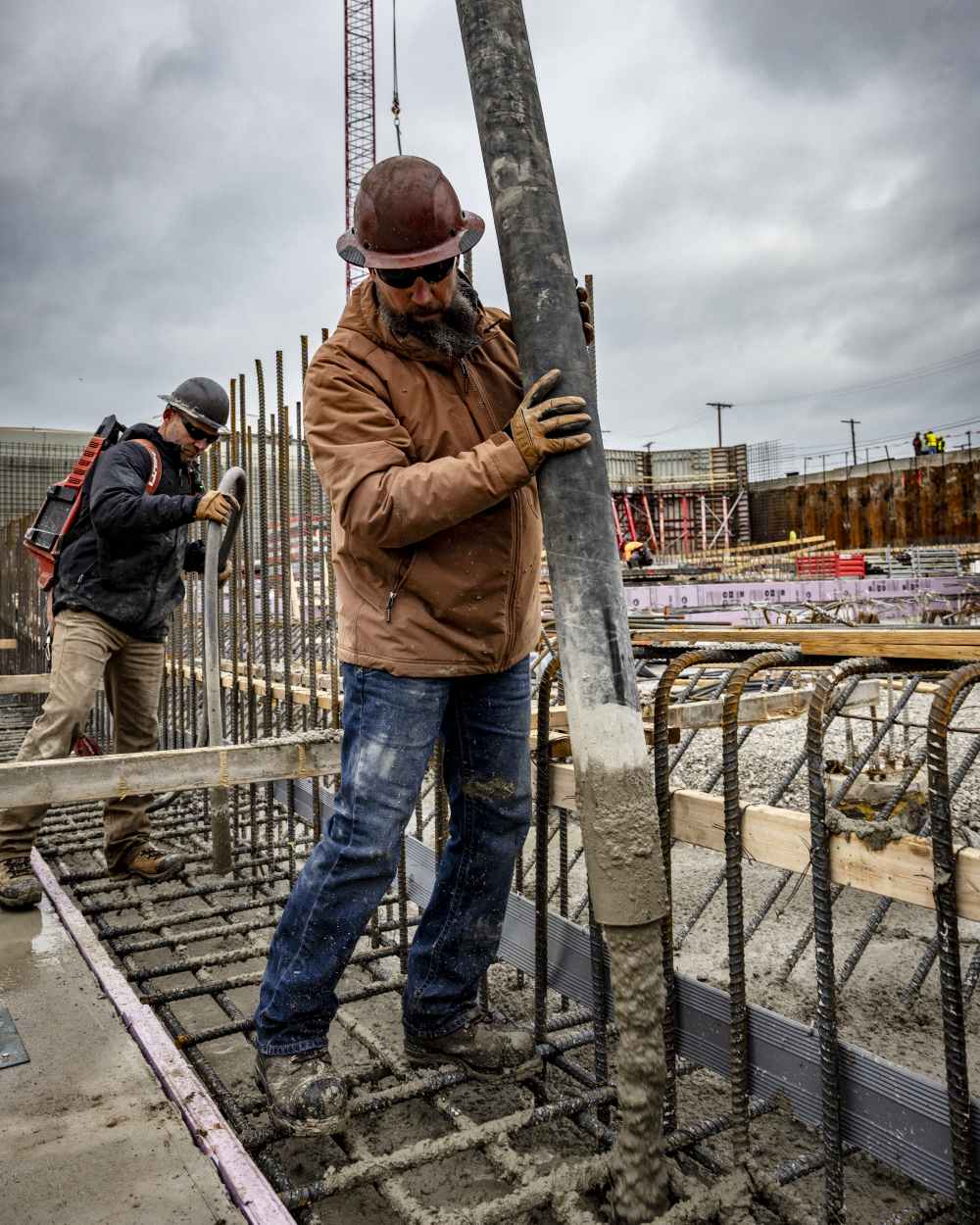 Aztec Coloured Ariat Rebar Cordura Ripstop Insulated Jacket On A Construction Site Background