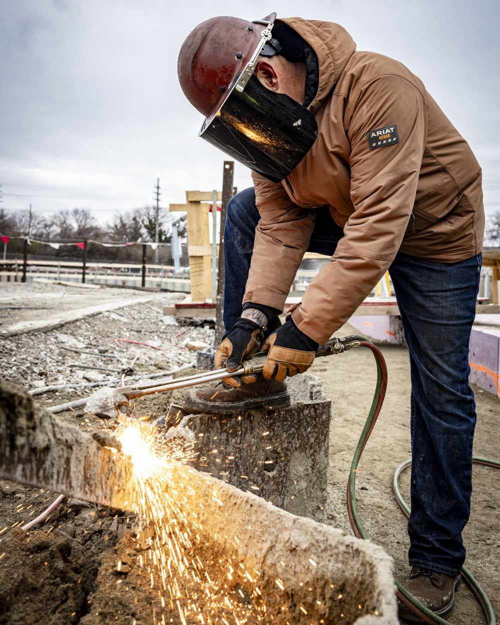 Aztec Coloured Ariat Rebar Cordura Ripstop Insulated Jacket On A Construction Site Background