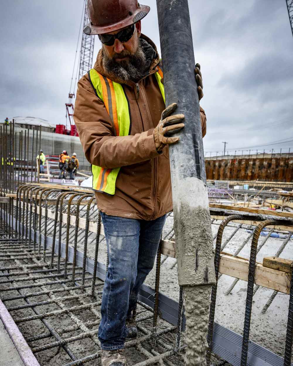 Aztec Coloured Ariat Rebar Cordura Ripstop Insulated Jacket On A Construction Site Background