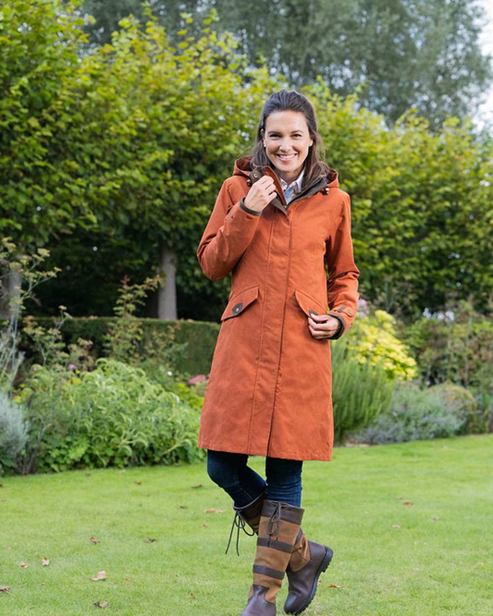 Terracotta Coloured Baleno Chelsea Mid Length Coat on garden background 