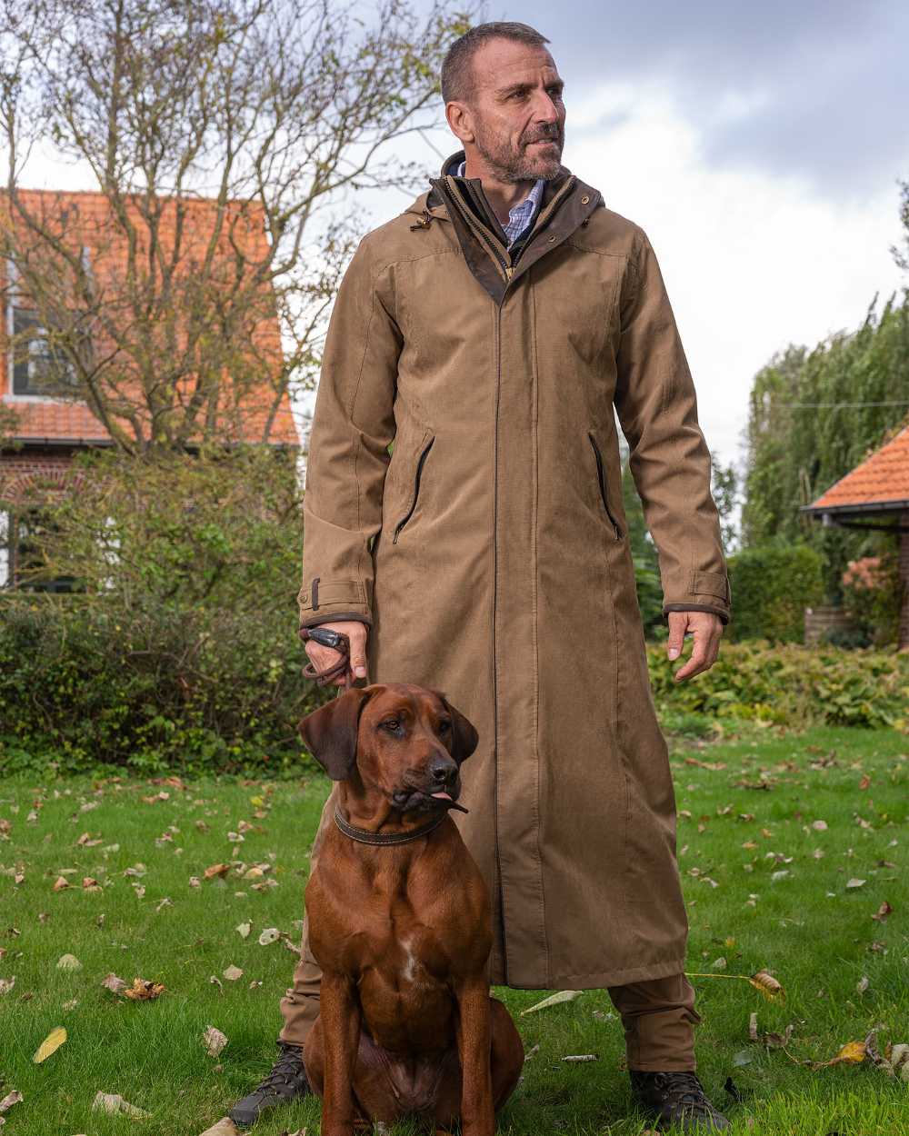 Camel Coloured Baleno Livingstone Long Waterproof Coat On A Backyard Background 