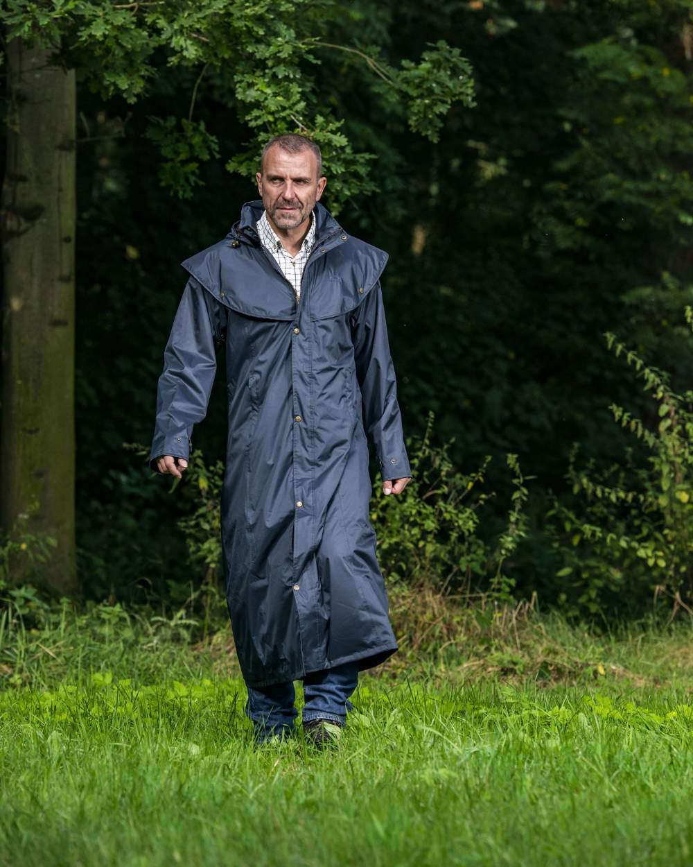 Navy Blue Coloured Baleno Newbury Waterproof Long Coat On A Forest Background 