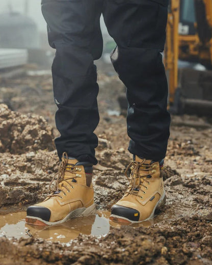 Honey Coloured Caterpillar Spiro Waterproof Safety Boot On A Mud Background 