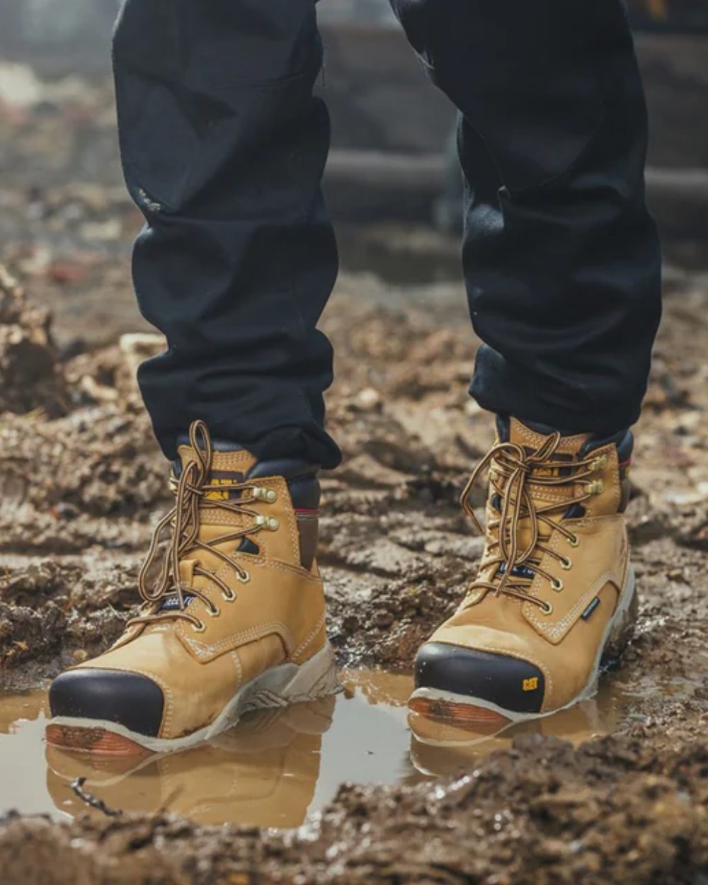 Honey Coloured Caterpillar Spiro Waterproof Safety Boot On A Mud Background 