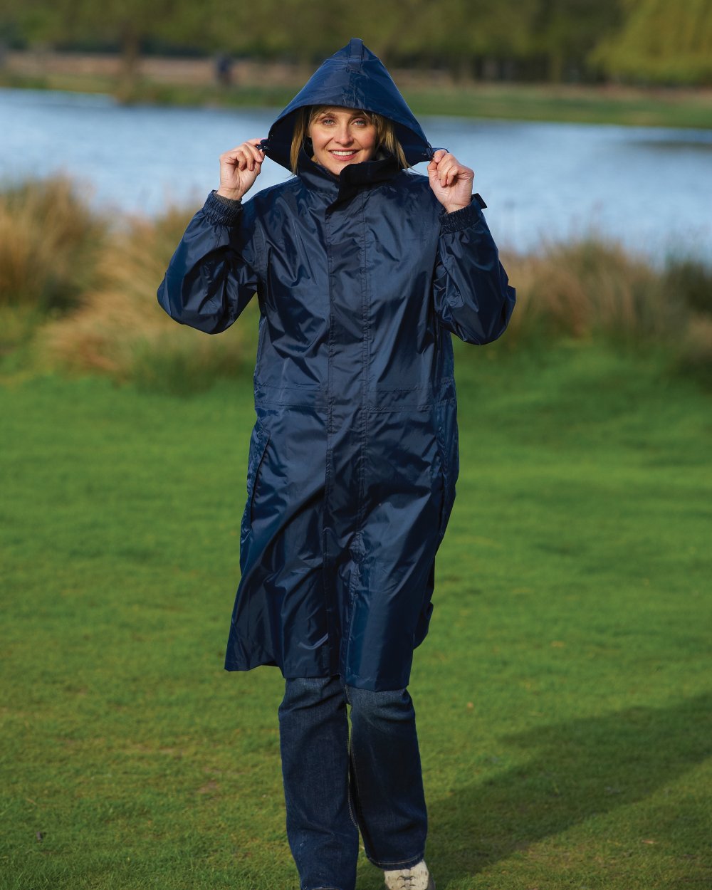 Navy Coloured Champion Storm Long Waterproof Coat On A Countryside Background