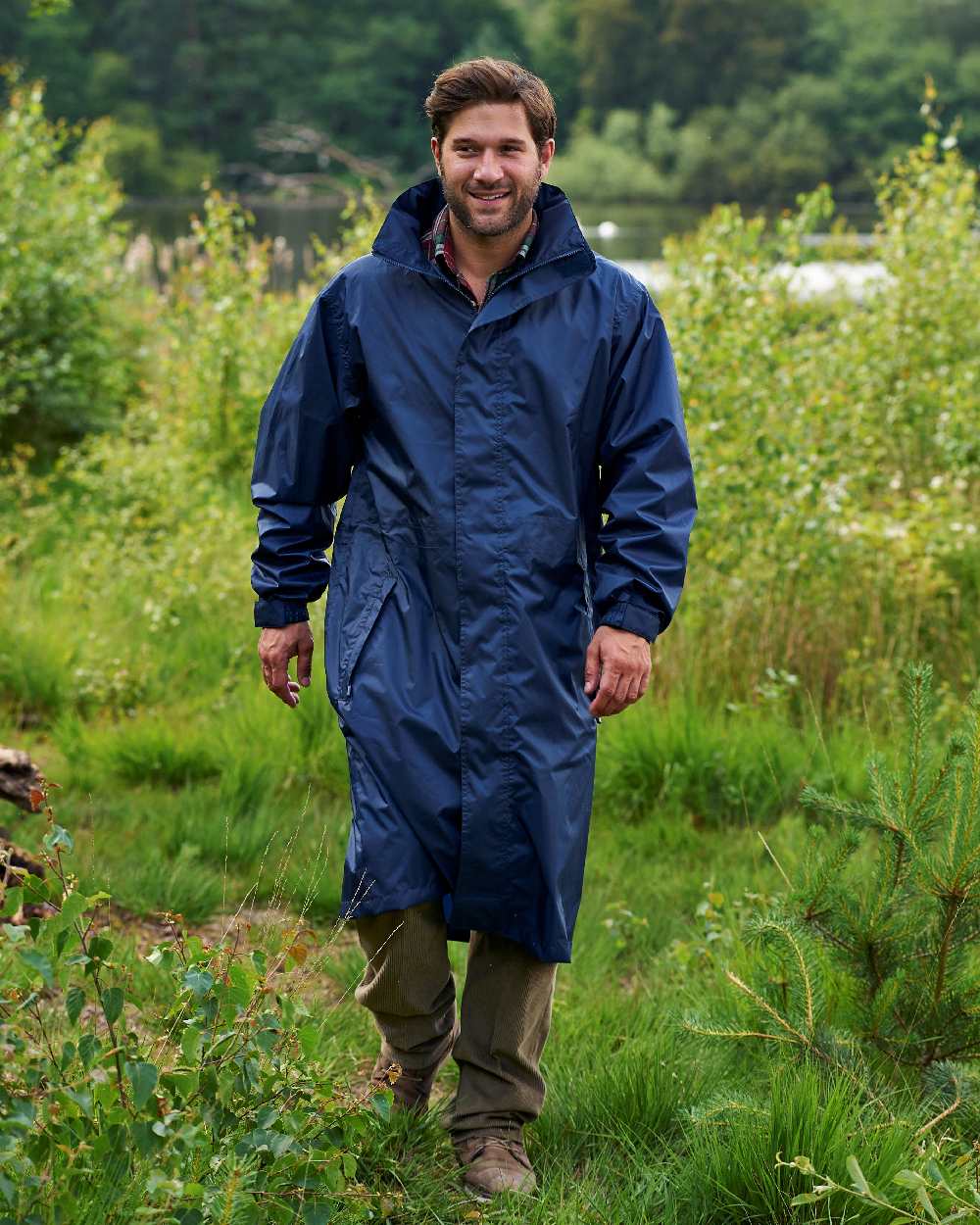 Navy Coloured Champion Storm Long Waterproof Coat On A Countryside Background