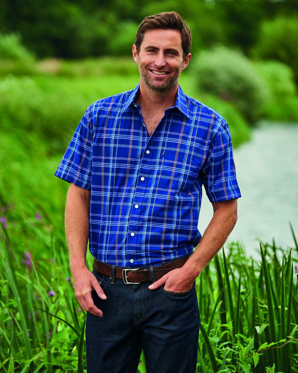 Blue Coloured Champion Whitby Short Sleeved Shirt On A Garden Background 