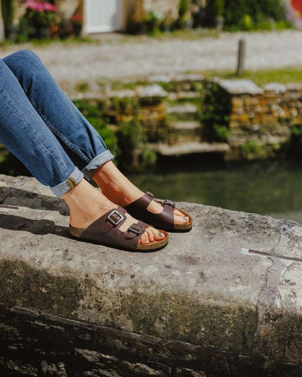 Brown Coloured Cotswold Womens Lushill Mules on River Background
