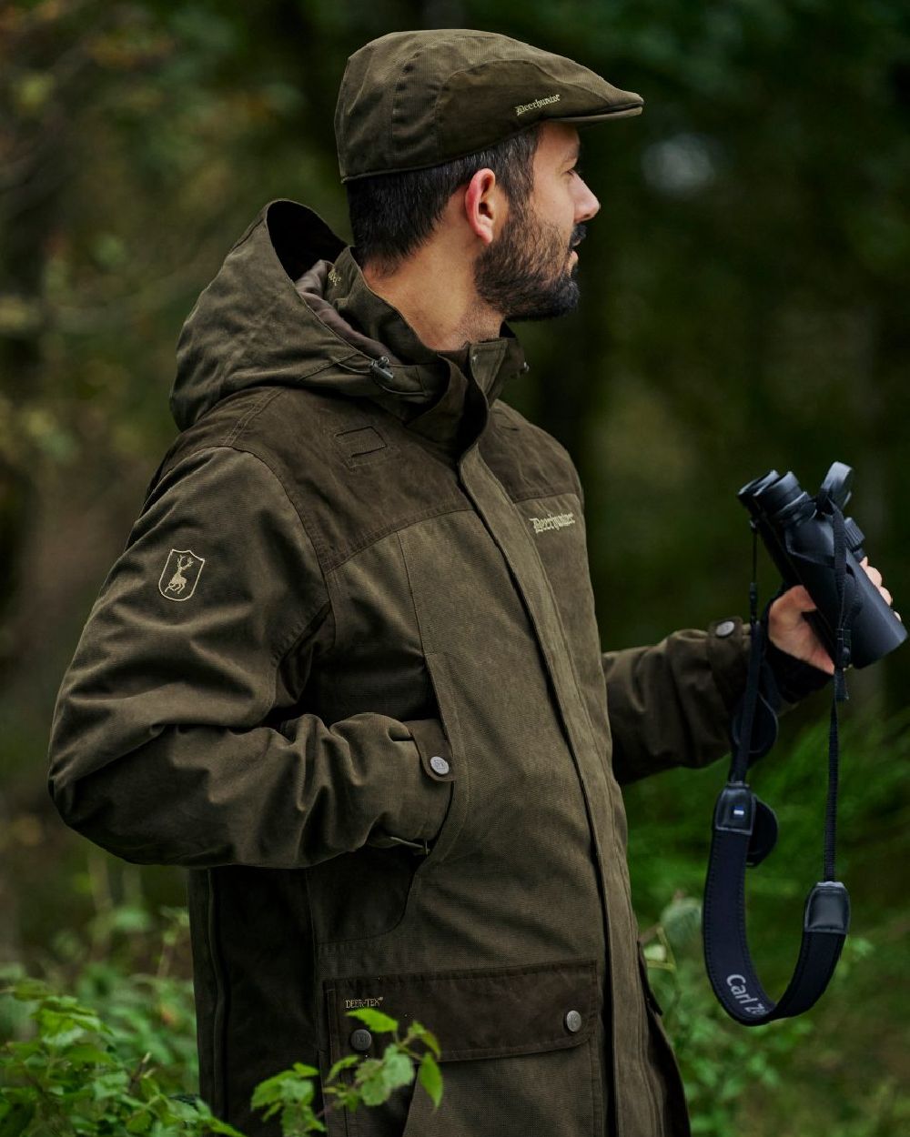 Tarmac Green coloured Deerhunter Eagle Flat Cap on forest background 