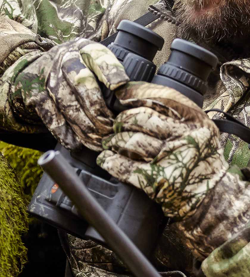 Deerhunter Camouflage shooting gloves hold a pair of stalking binoculars | Deerhunter gloves